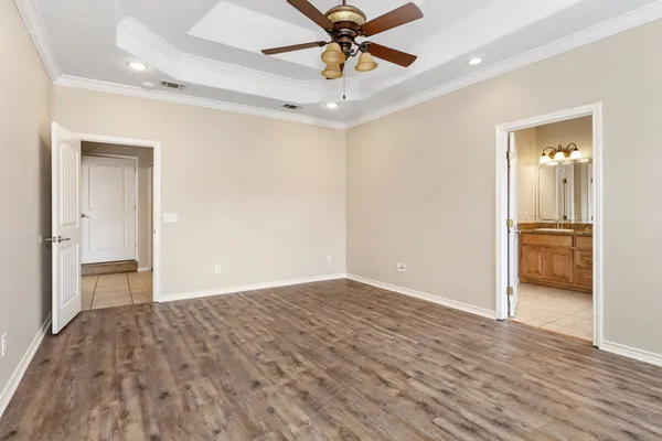 a view of a livingroom with a chandelier fan and wooden floor