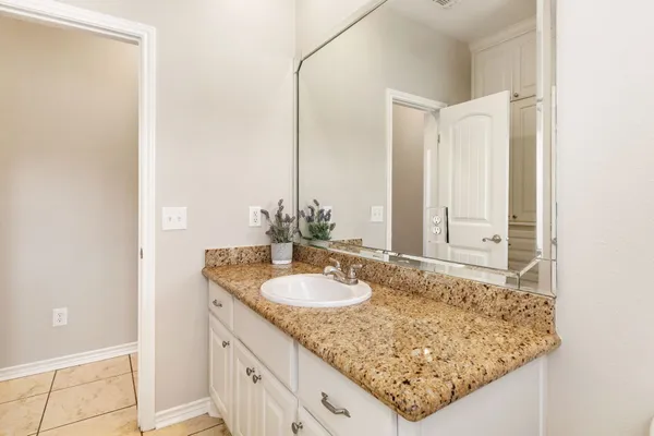 a bathroom with a granite countertop sink and a mirror