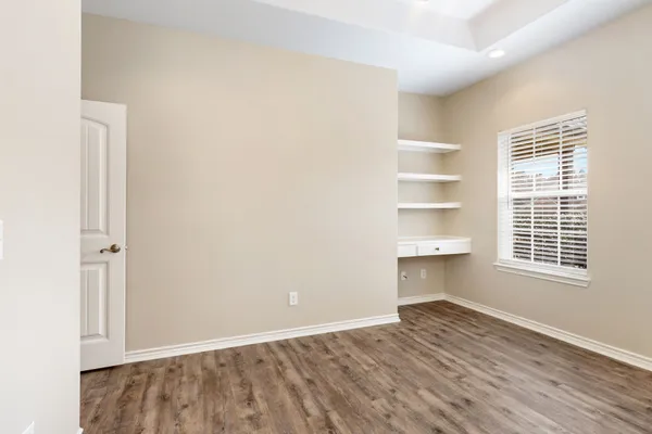 a view of a room with wooden floor and a window