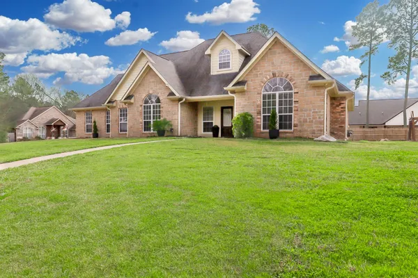 a view of a house with a big yard and large trees