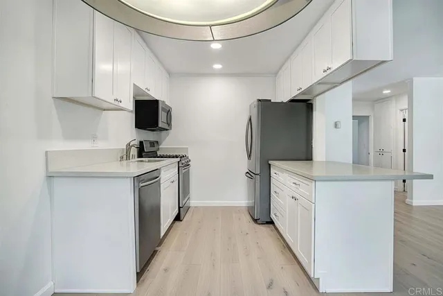 a kitchen with white cabinets and stainless steel appliances