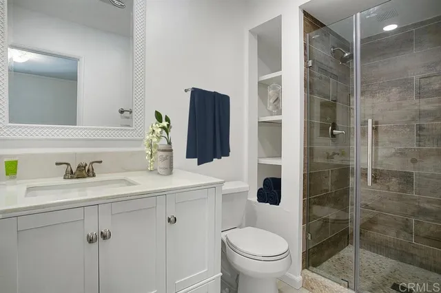 a bathroom with a sink a toilet and shower