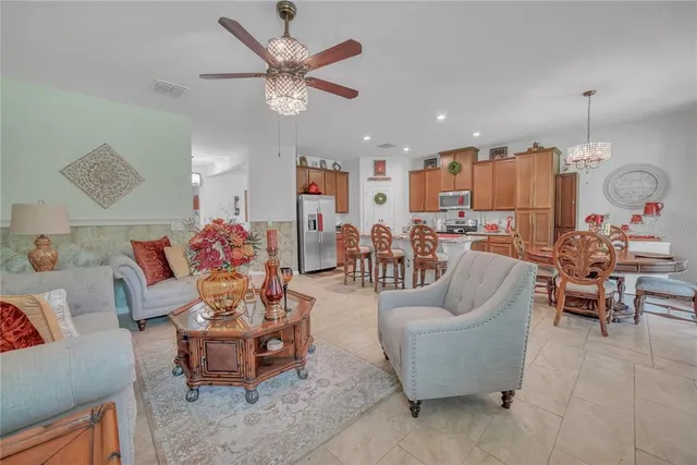 a living room with furniture kitchen view and a chandelier