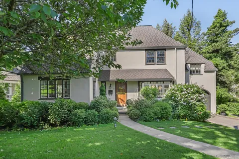 a front view of a house with a yard and trees