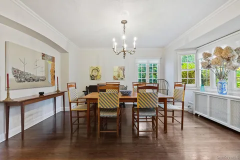a view of a dining room with furniture a chandelier and wooden floor