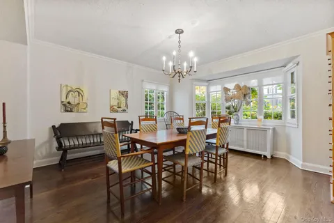 a view of a dining room with furniture a chandelier and wooden floor