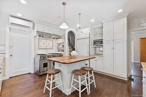 a kitchen with granite countertop a stove a sink and a refrigerator