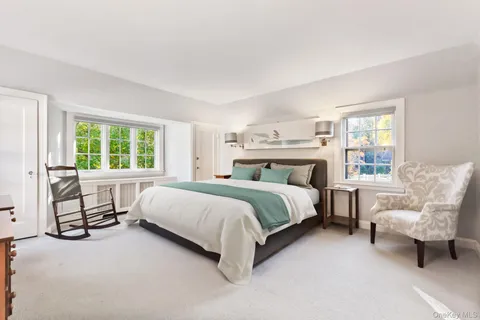 a bedroom with a bed chair and window