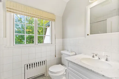 a bathroom with a sink a toilet and a window