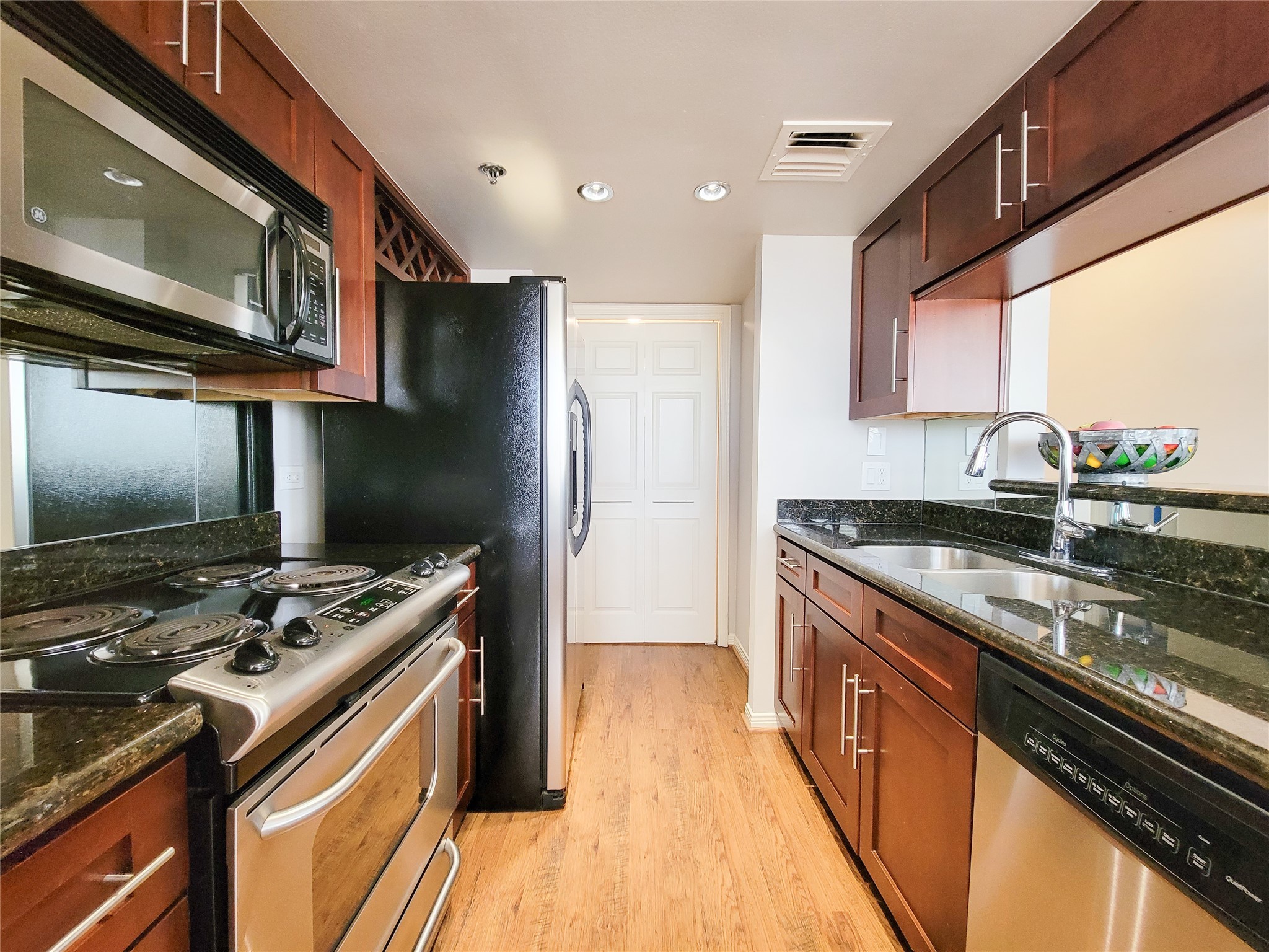3525 Sage Road, Unit 303 Houston, TX 77056 - Photo 22 of 41 Chef's Kitchen with stainless steel appliances, granite countertops, recessed lighting and laminate flooring. Laundry is located at the end of the Kitchen, as well as pantry space.