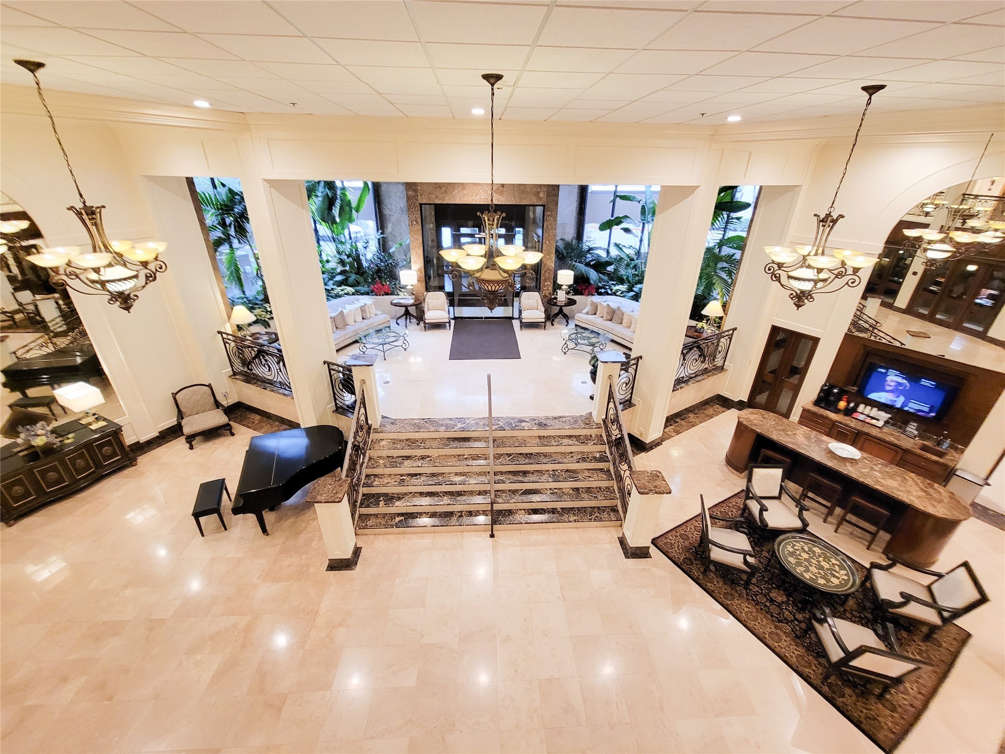 3525 Sage Road, Unit 303 Houston, TX 77056 - Photo 6 of 41 View or the Lobby from the Mezzanine, shows the inviting entrance for residents and guests, the Grand Piano for everyone's use and the Coffee Bar to the right.