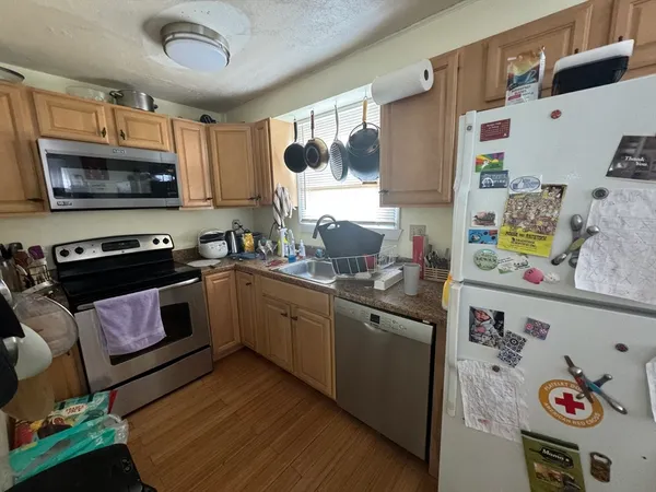 a kitchen with stainless steel appliances granite countertop a stove a sink and a microwave
