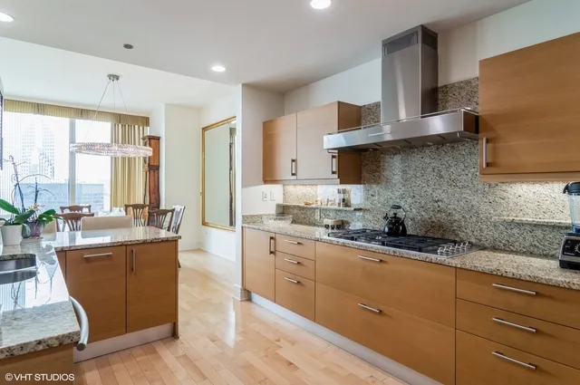 a kitchen with stainless steel appliances granite countertop a sink a stove and cabinets