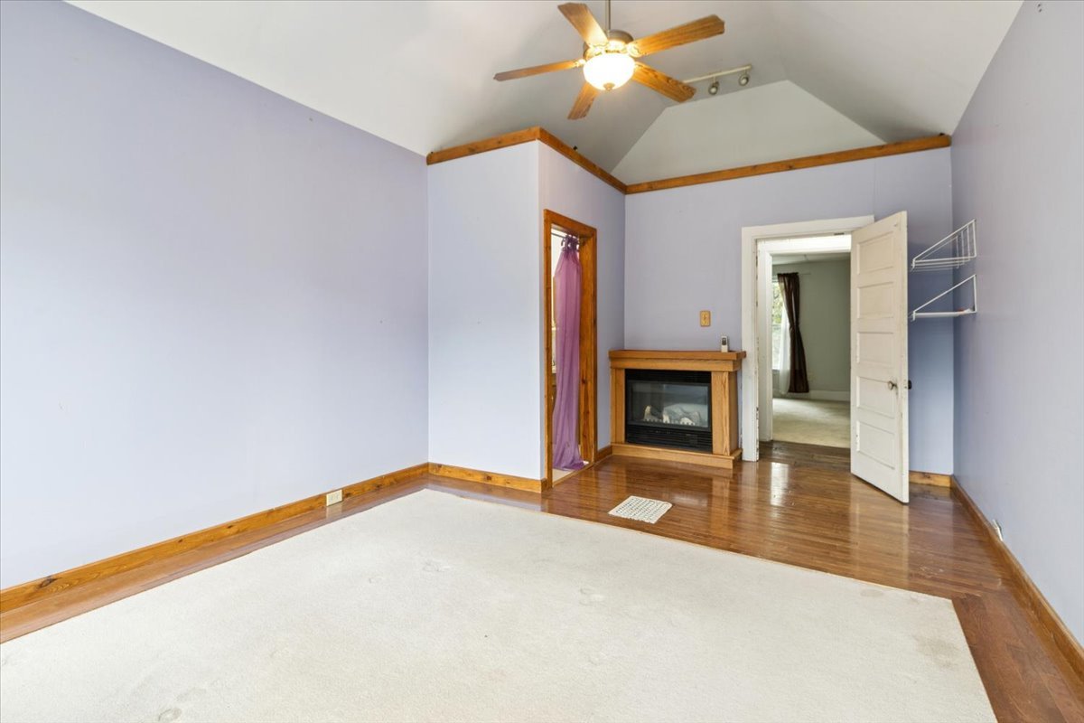310 South Sycamore Street Genoa, IL 60135 - Photo 16 of 21 a view of an empty room with a fireplace and a chandelier fan