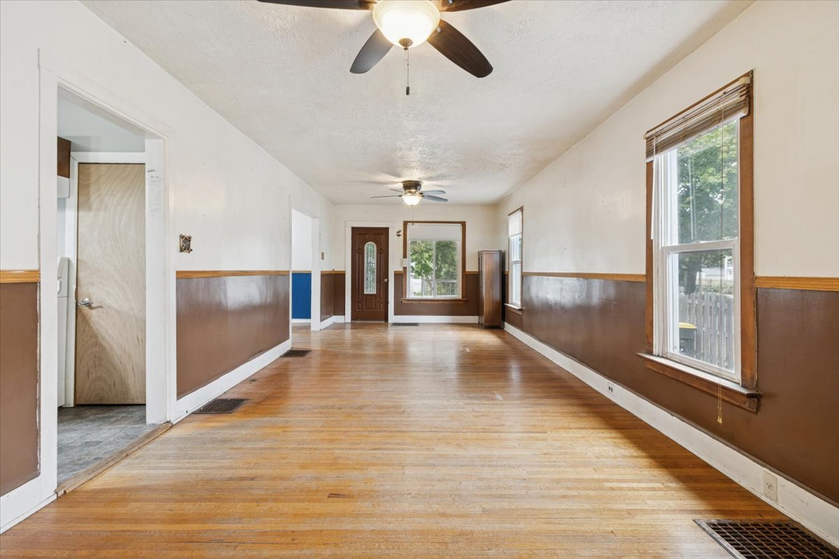 310 South Sycamore Street Genoa, IL 60135 - Photo 5 of 21 a view of an empty room with wooden floor and a window