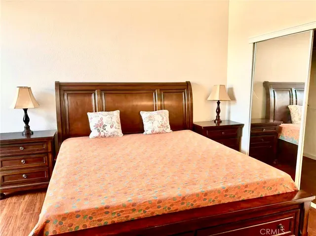 a large bed sitting in a bedroom and dressers next to a larger window