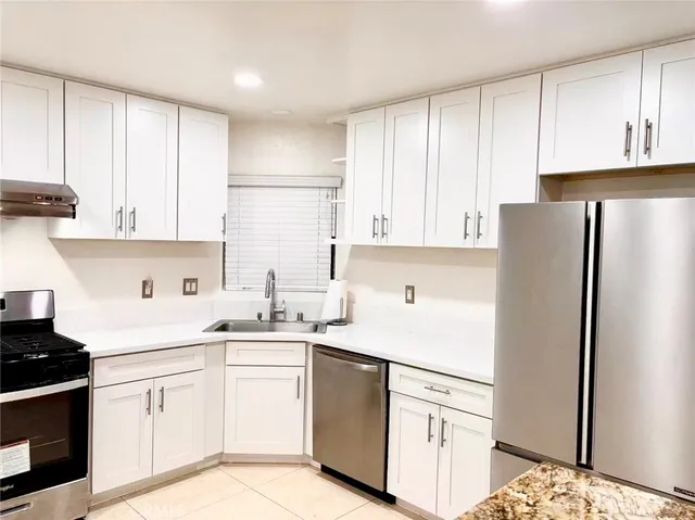 a kitchen with white cabinets and white appliances