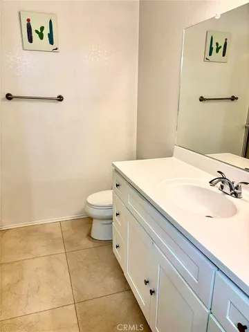 a spacious bathroom with a granite countertop sink a toilet and a mirror