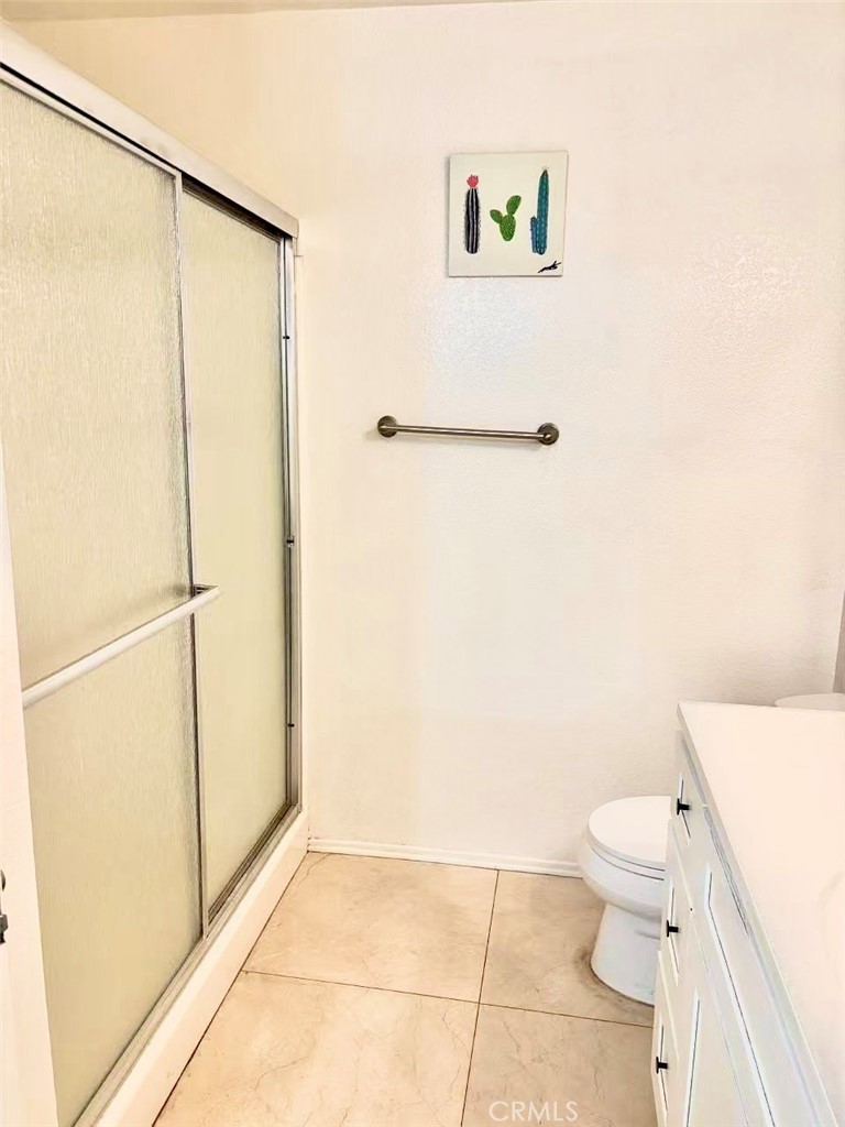 18 Town And Country Road, Unit 34 Pomona, CA 91766 - Photo 24 of 26 a bathroom with a granite countertop shower and a toilet