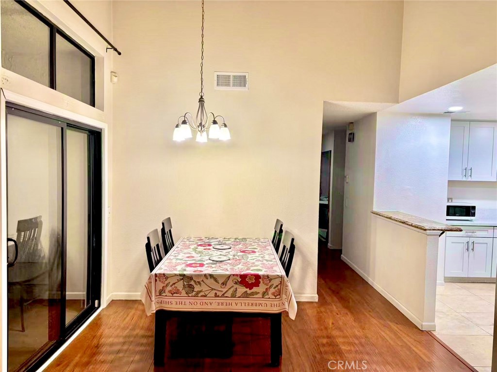 18 Town And Country Road, Unit 34 Pomona, CA 91766 - Photo 5 of 26 a kitchen with stainless steel appliances granite countertop a stove a refrigerator and a wooden floor