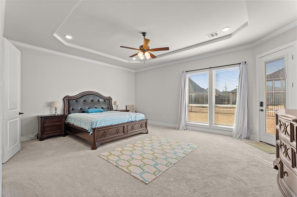 600 St Andrew Lane Prosper, TX 75078 - Photo 14 of 29 Bedroom with light carpet, access to outside, ornamental molding, a ceiling fan, and a tray ceiling