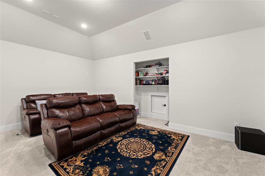 600 St Andrew Lane Prosper, TX 75078 - Photo 19 of 29 Living area with light carpet, lofted ceiling, and built in features