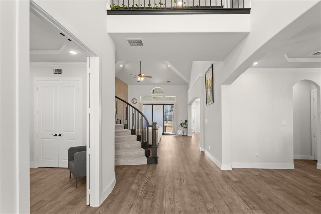 600 St Andrew Lane Prosper, TX 75078 - Photo 22 of 29 Entryway with recessed lighting, crown molding, wood finished floors, arched walkways, and a high ceiling