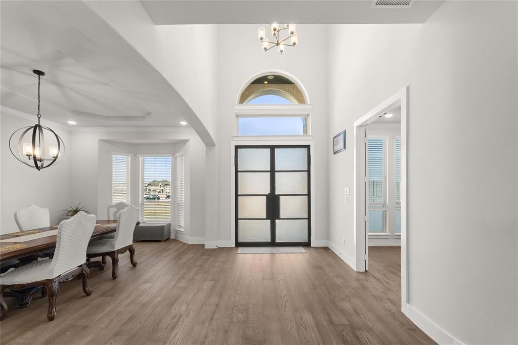 600 St Andrew Lane Prosper, TX 75078 - Photo 3 of 29 Foyer entrance featuring hanging lights, wood finished floors, and a high ceiling
