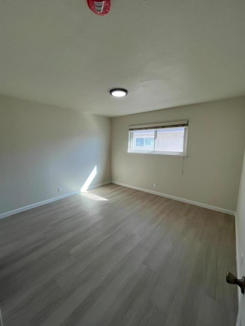 591 Nello Drive, Unit 4 Campbell, CA 95008 - Photo 15 of 33 an empty room with wooden floor and windows
