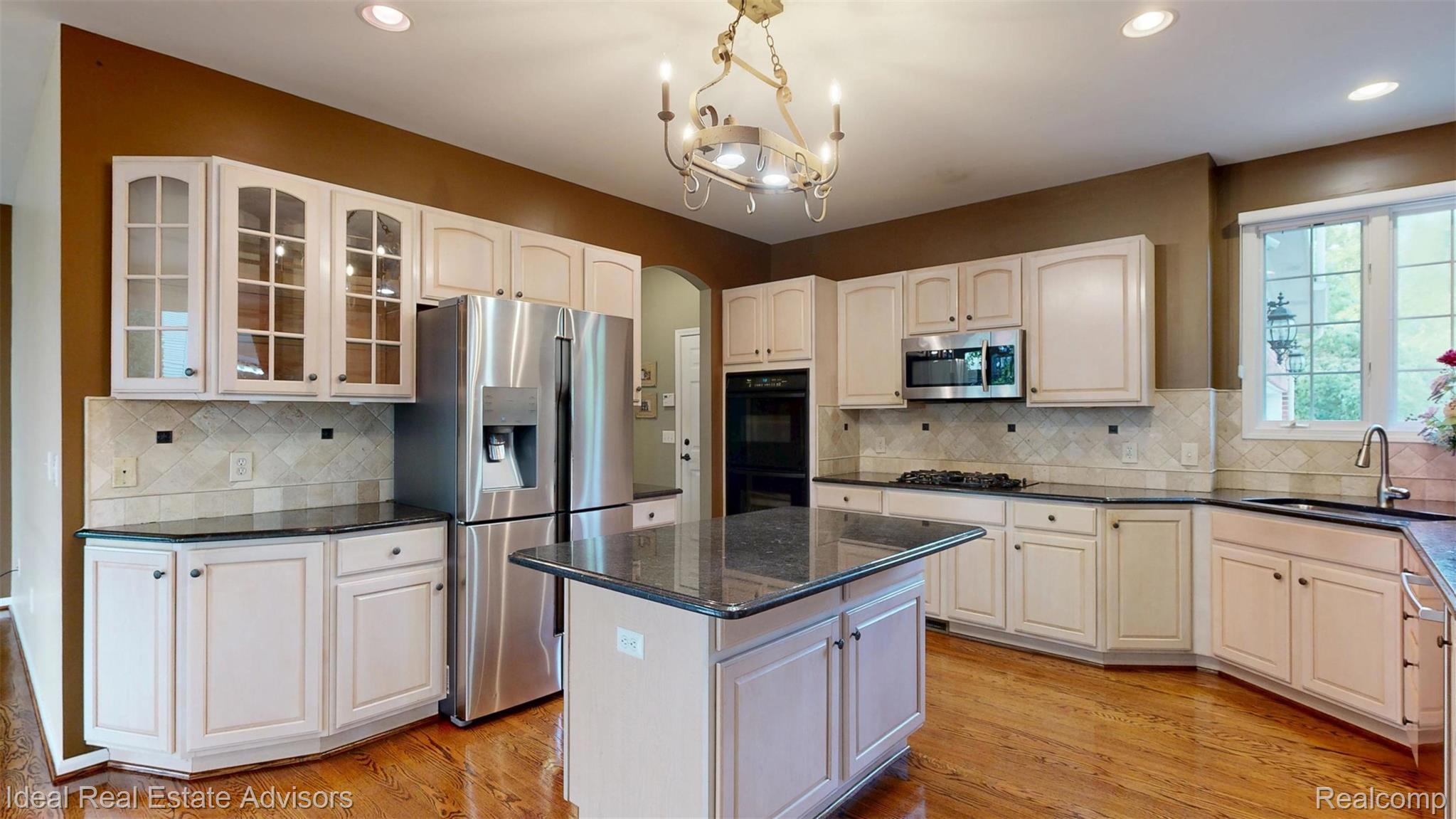 1364 Kentfield Drive Rochester, MI 48307 - Photo 29 of 70 Expansive kitchen featuring light-toned cabinetry, dark countertops, a central island, stainless steel appliances, and wood-finish flooring