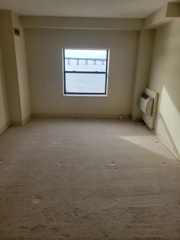 a view of a small space with wooden floor and a window