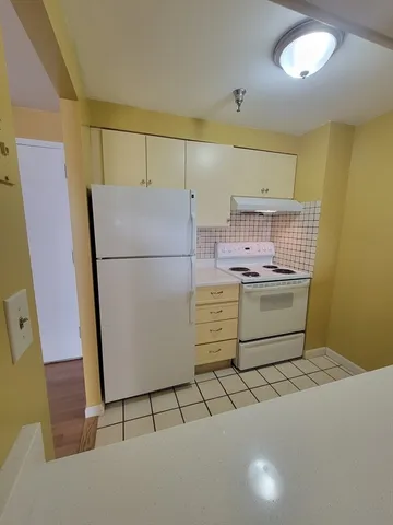 a kitchen with a refrigerator and a stove