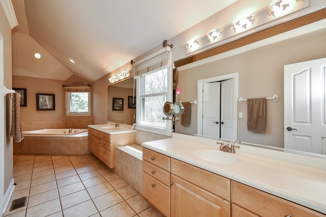 37W571 Grey Barn Road St. Charles, IL 60175 - Photo 13 of 31 a large white bathroom with a large mirror vanity and a bathtub