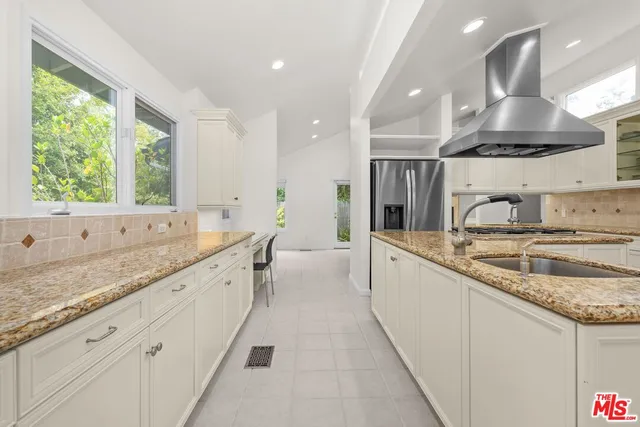 a large white kitchen with a large window