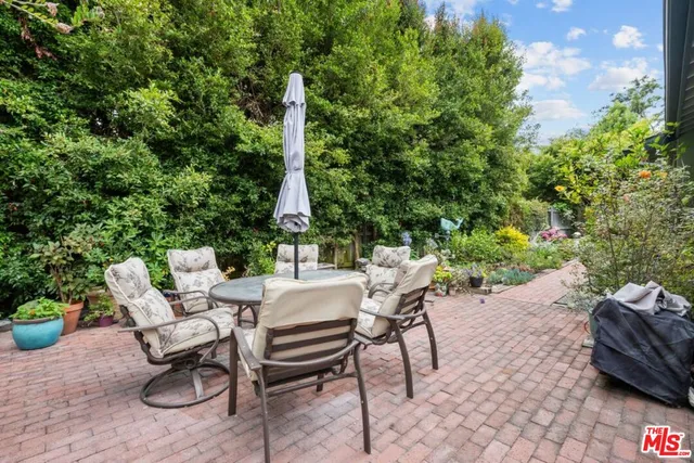 a view of a patio with a table and chairs and potted plants