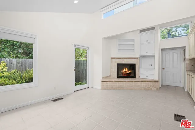 a view of an empty room with a fireplace and a window
