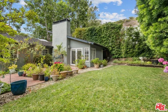 a view of a house with backyard and sitting area