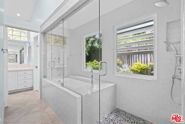 a bathroom with a tub sink and glass door