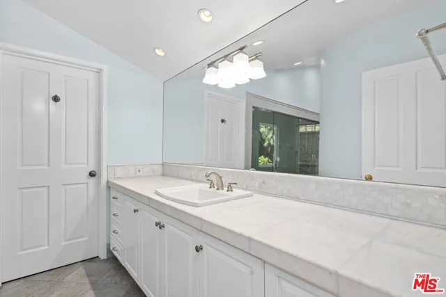 a bathroom with a sink vanity and a mirror