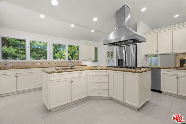 a kitchen with granite countertop a sink and white cabinets
