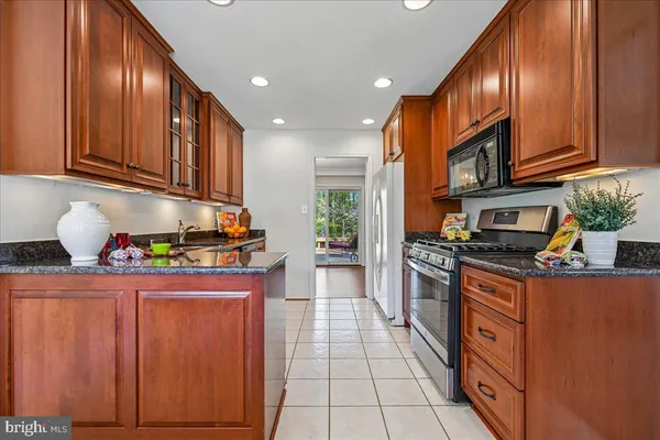 a kitchen with stainless steel appliances granite countertop cabinets and a stove top oven