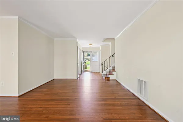 a view of a room with wooden floor staircase and a chandelier
