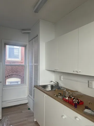 a kitchen with granite countertop a sink window and cabinets