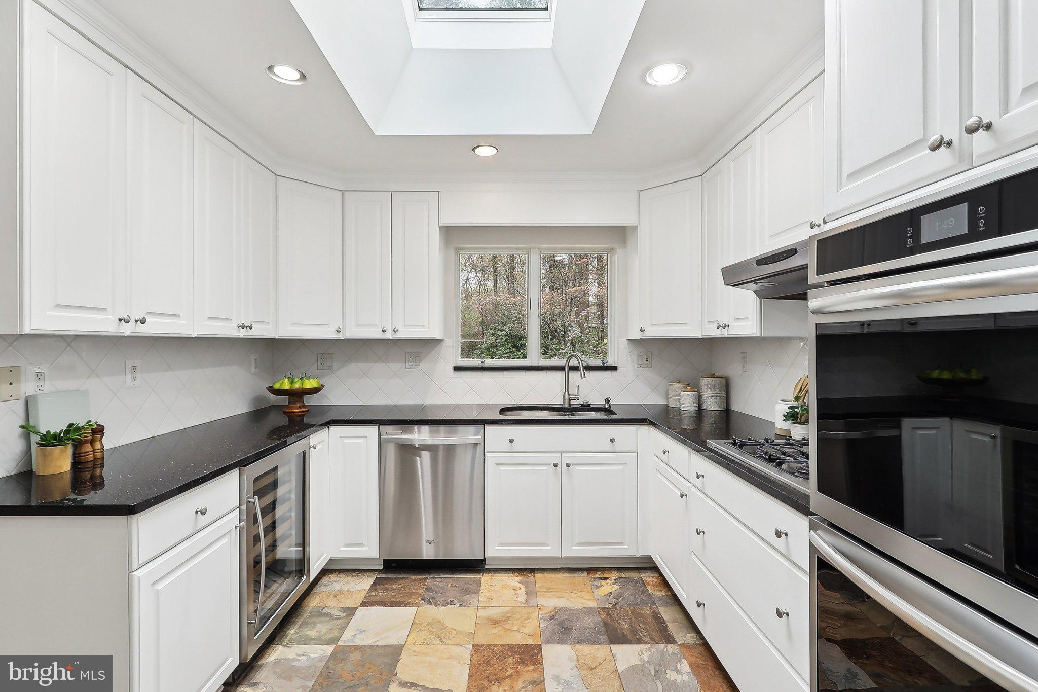 4212 Wakefield Drive Annandale, VA 22003 - Photo 17 of 67 a kitchen with a sink dishwasher a stove and white cabinets