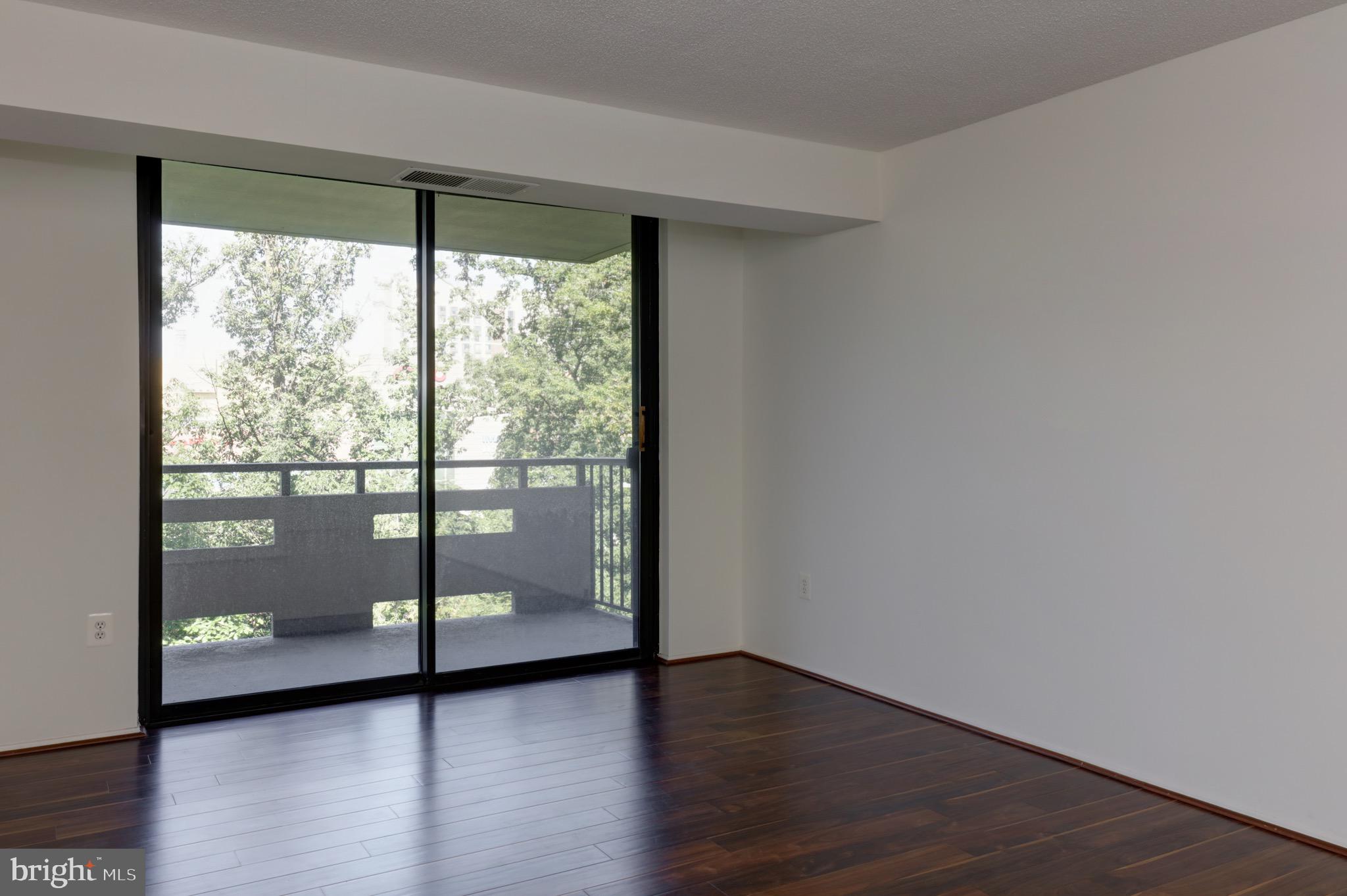 a view of a big room with wooden floor and doors