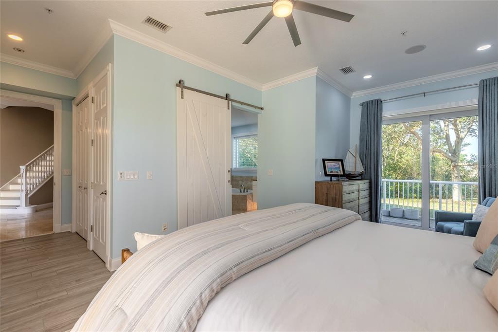 4641 Riverwalk Village Court Ponce Inlet, FL 32127 - Photo 29 of 74 a bedroom with a large bed and a large window