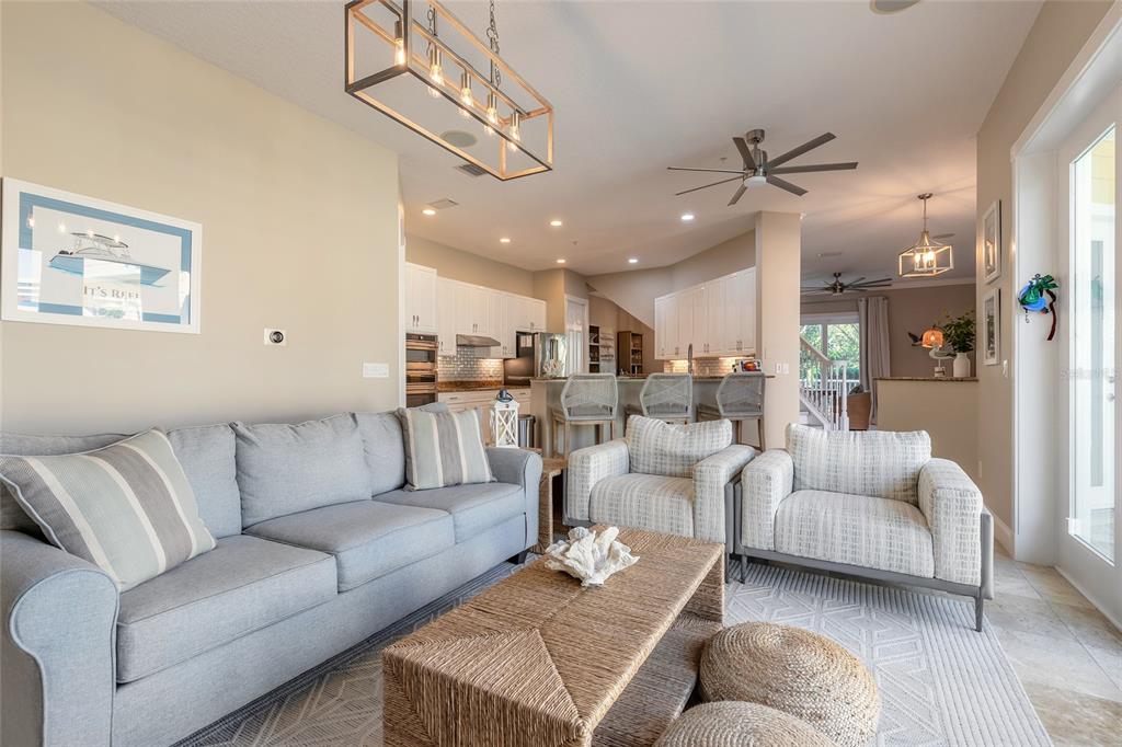 4641 Riverwalk Village Court Ponce Inlet, FL 32127 - Photo 42 of 74 a living room with furniture kitchen view and a chandelier