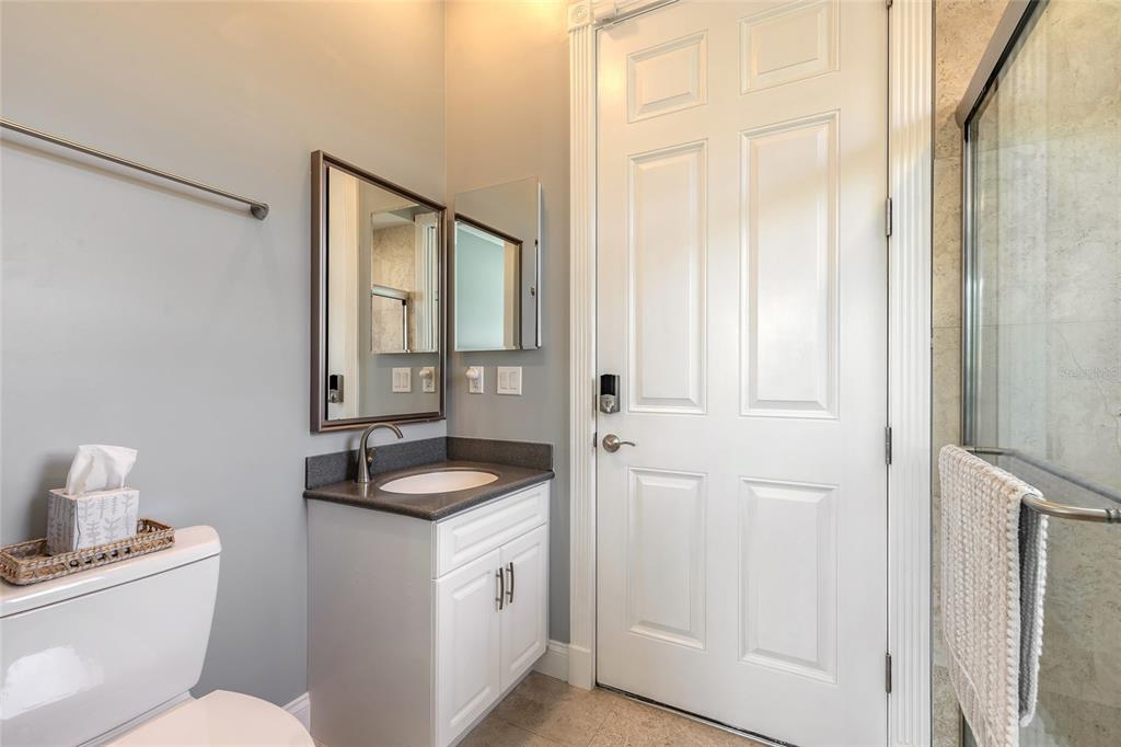 4641 Riverwalk Village Court Ponce Inlet, FL 32127 - Photo 62 of 74 a bathroom with a granite countertop sink and a mirror
