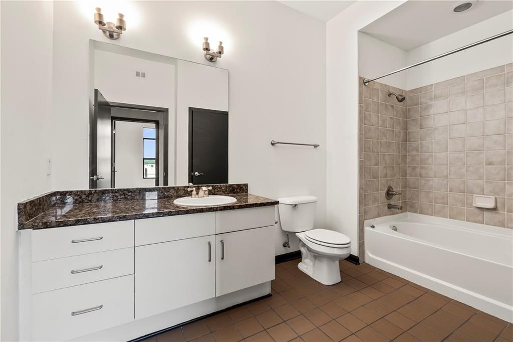 5300 Peachtree Road, Unit 2605 Chamblee, GA 30341 - Photo 14 of 26 a bathroom with a granite countertop toilet a sink and a bathtub