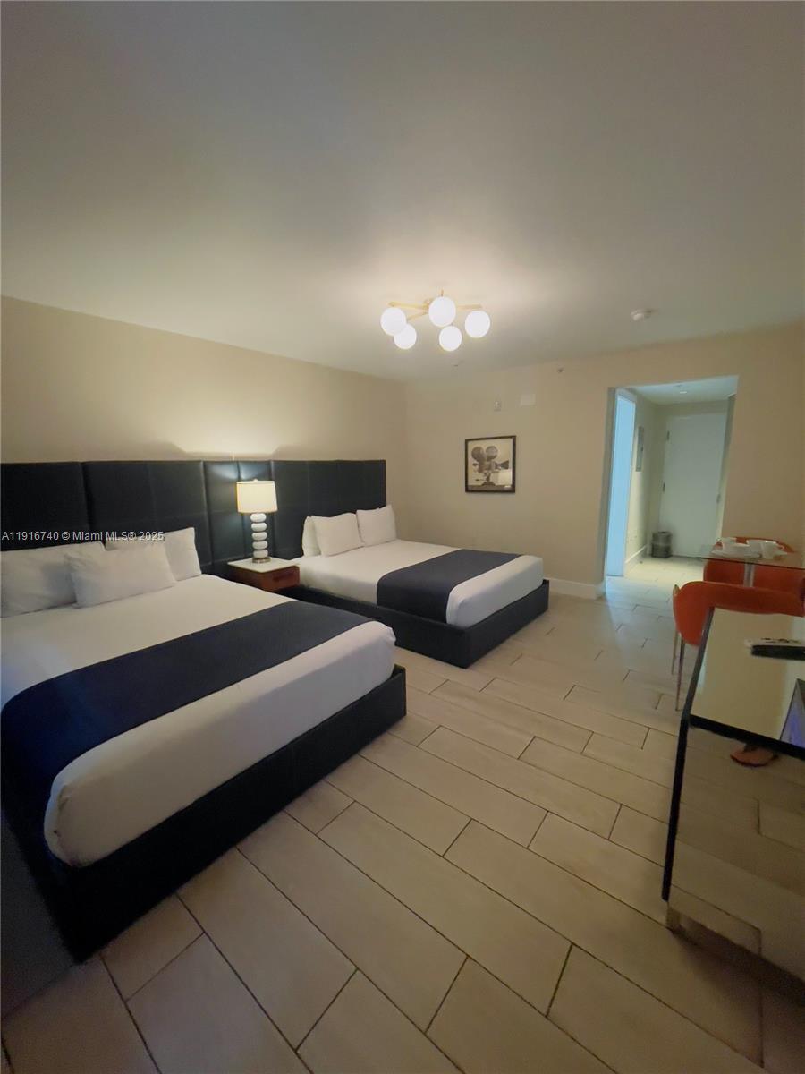 7310 Harding Avenue, Unit 309 Miami Beach, FL 33141 - Photo 3 of 8 a bedroom with double bed and a couch